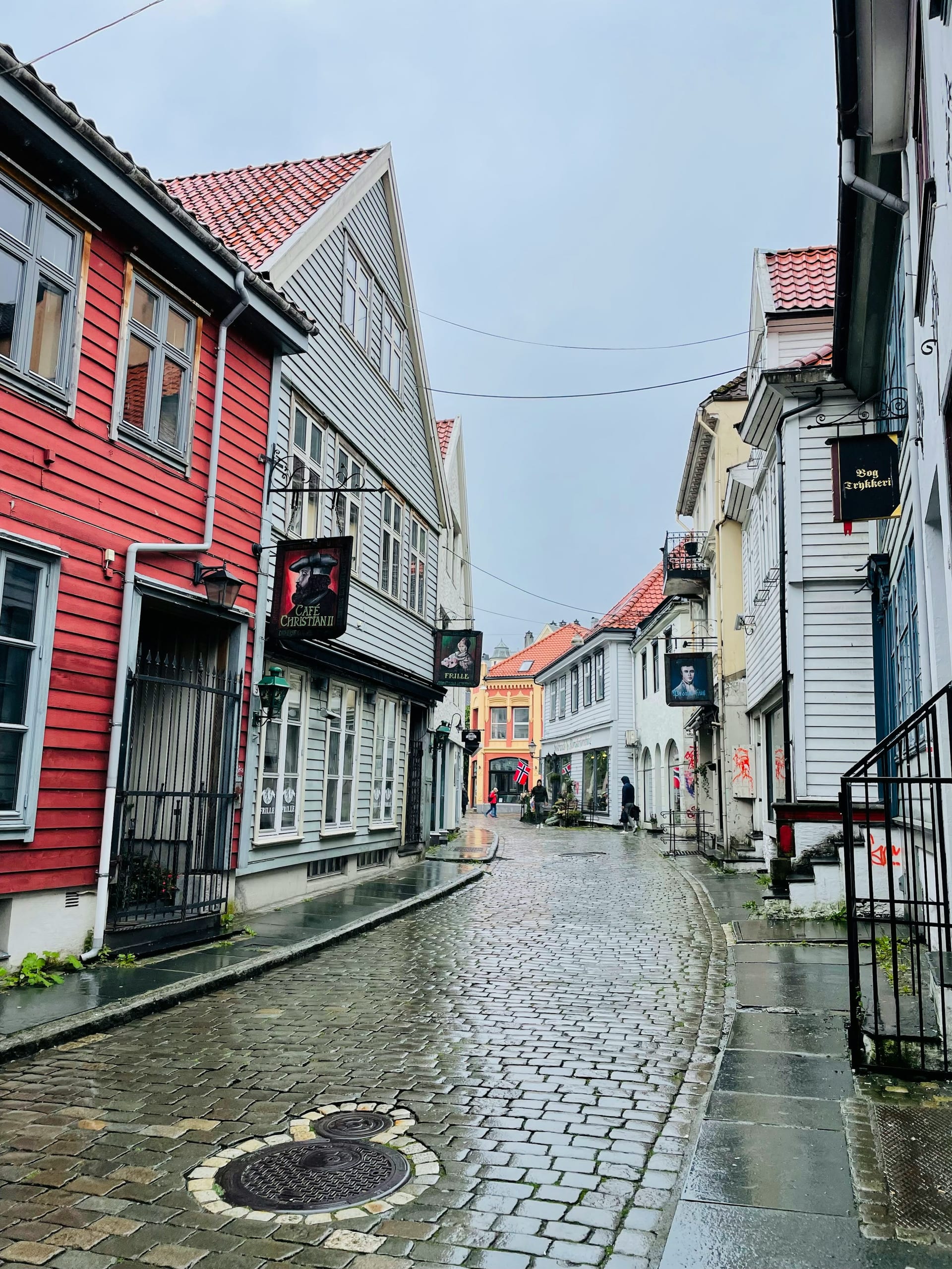 A narrow cobblestone alley between old wooden buildings in Bergen's historic centre