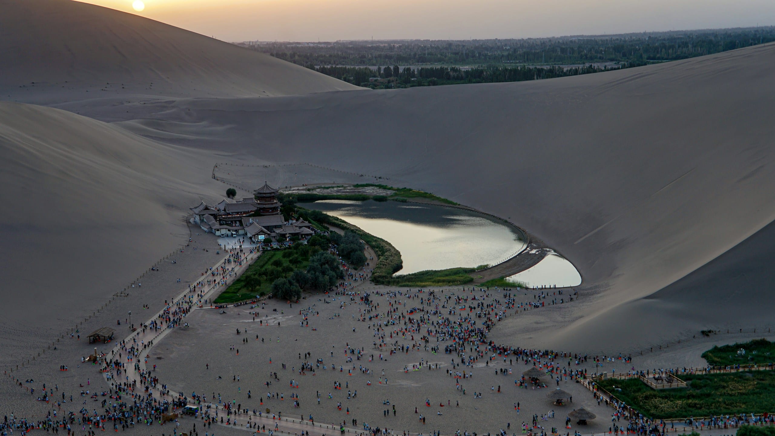 Aerial view of Crescent Lake oasis surrounded by sand dunes at Mingsha Mountain near Dunhuang