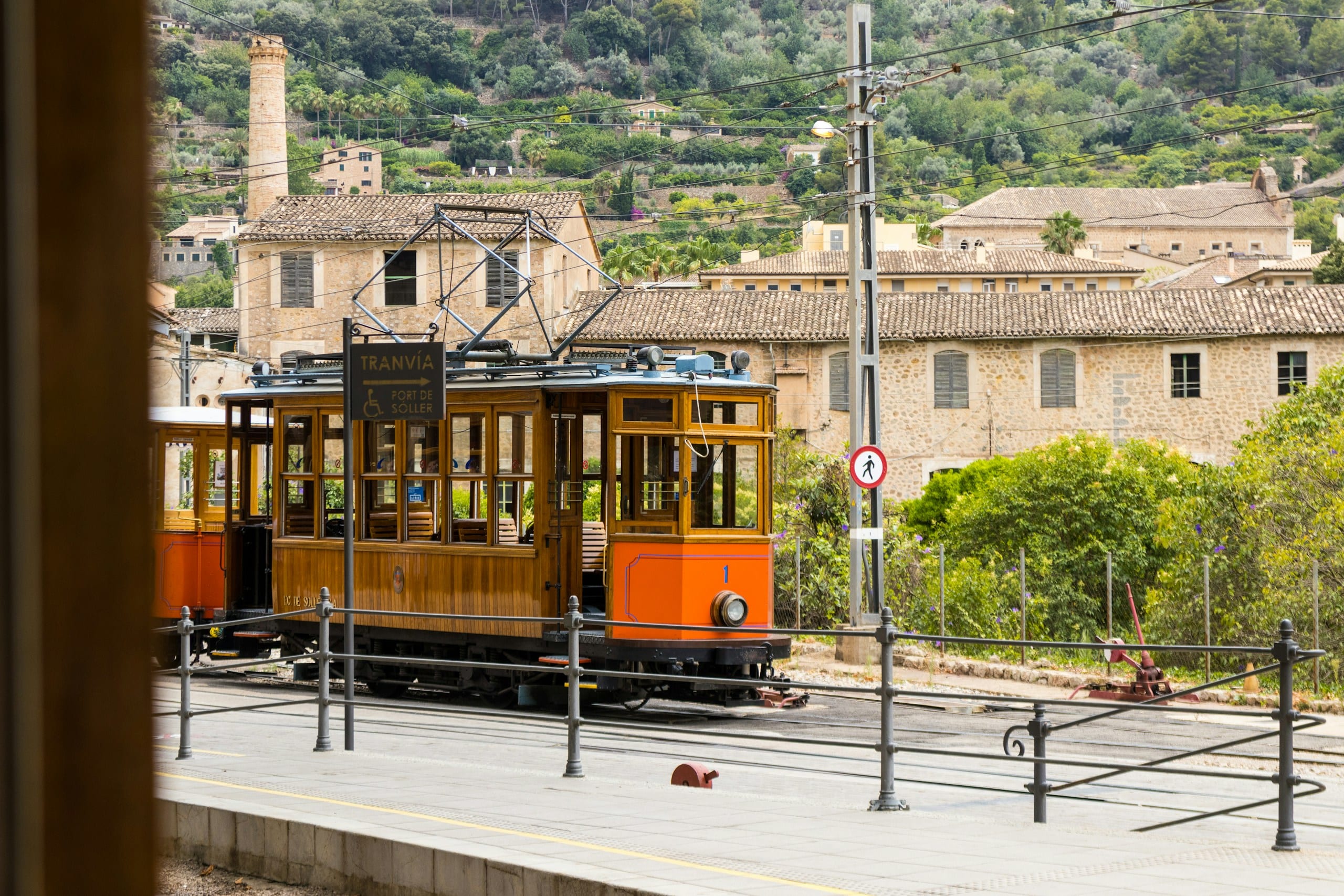 The vintage orange wooden tram of Sóller rolling along the waterfront at Port de Sóller in Mallorca