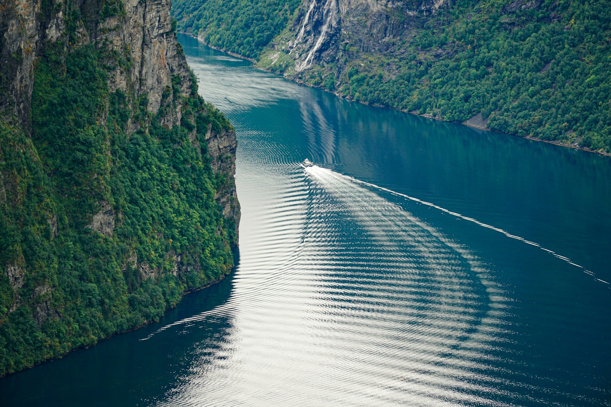 Geirangerfjord seen from a high viewpoint with green mountains plunging to the water far below