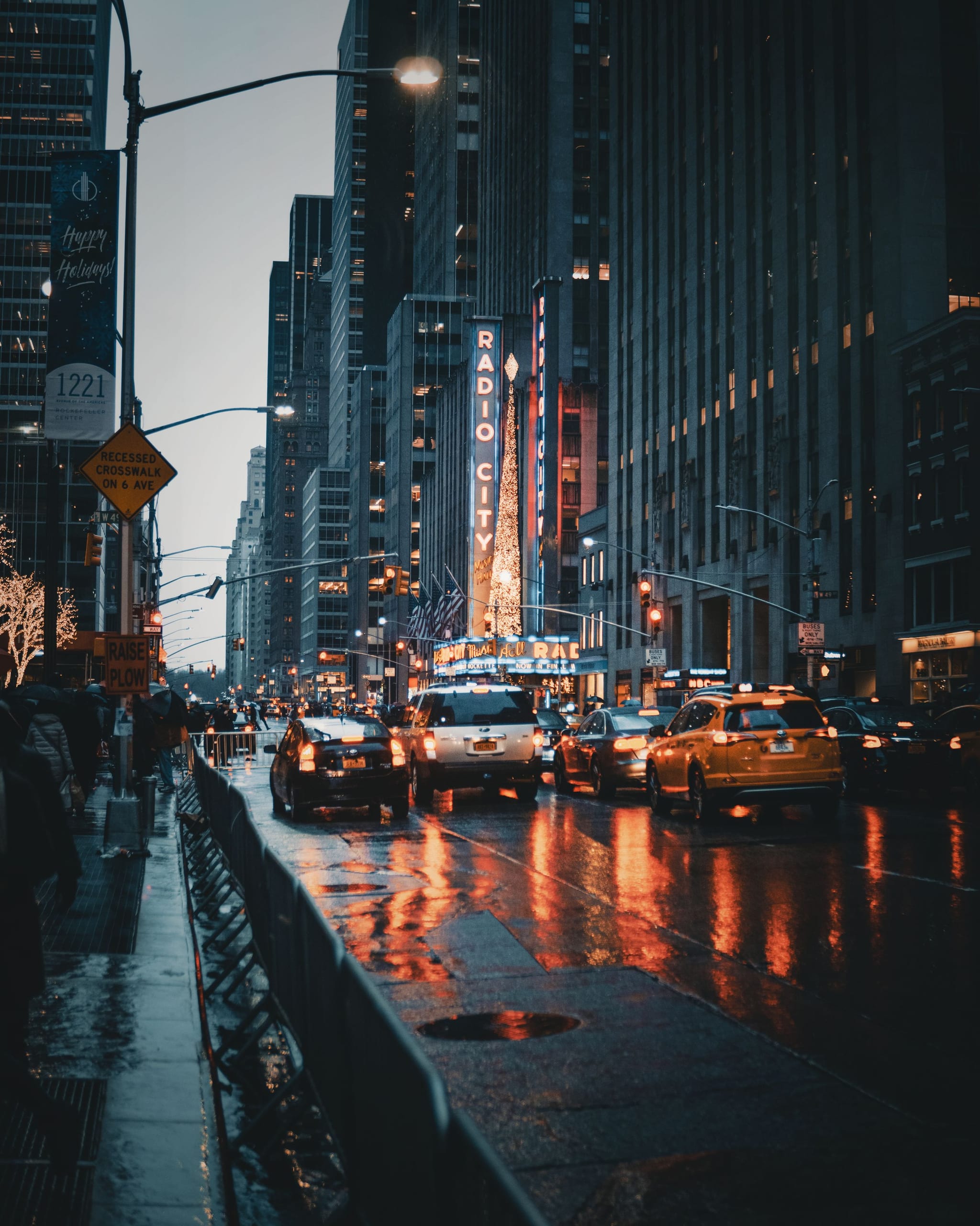 Wet city street at night with reflections of headlights and neon on the pavement